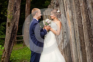 Groom and bride near fence in park