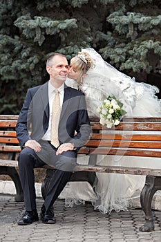 Groom and the bride in park on a bench