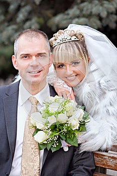 Groom and the bride in park on a bench