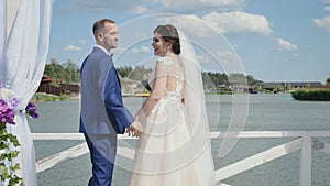 Groom and bride shows a thumbs up at river background