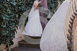 Groom with bride on stairs near the building