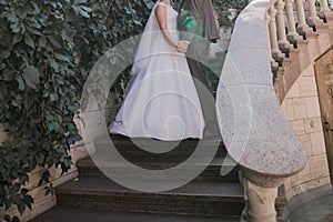 Groom with bride on stairs near the building