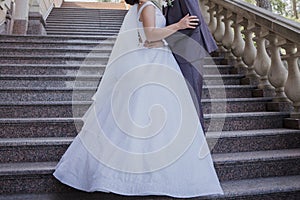 Groom with bride on stairs near the building