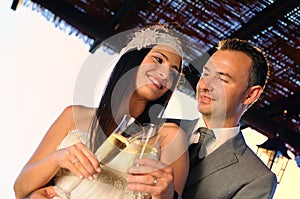 Groom and bride toasting on a terrace smiling eye contact