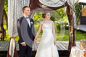 Groom and bride under decorative wedding arch