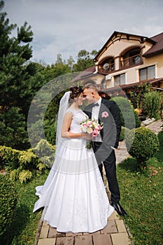 Groom and bride walk in the park on their wedding day. Happy couple spend time together