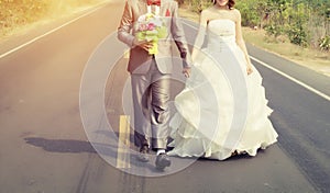 Groom and bride walking in the road go to marry