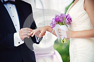 Groom and bride during wedding ceremony, close up on hands. Wedding couple and outdoor wedding ceremony