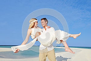 Groom Carrying Bride At Beautiful Beach Wedding