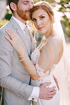 Groom, closed his eyes, embraces the bride. Close-up