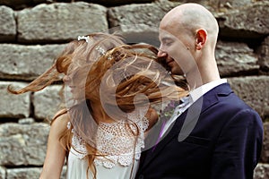 Groom daydreams while bride's hair touches his face photo