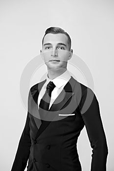 Groom dressed for wedding or holiday celebration. Ballroom dancer in stylish tuxedo. Man in elegant suit with tie. Dress code for