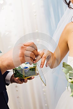 Groom dresses the wedding ring of his beloved bride