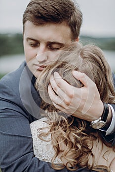 Groom embracing and hugging beautiful gorgeous bride. happy sensual wedding couple in love, atmospheric mood. happy romantic