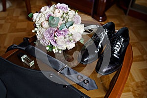 The groom is gathering in the morning. Men`s Black classic patent leather shoes, tie and waistcoat. Black belt. Wedding