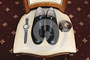 Groom is gathering in the morning.Men& x27;s classic shoes, belt,toilette, perfume, leather strap watch, wedding rings