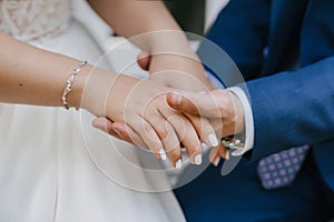 Groom gently holds the bride`s hand at the wedding ceremony