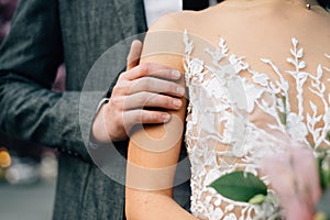 The groom gently strokes the bride. Closeup hands