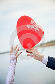 Groom gives a balloon form of heart to bride