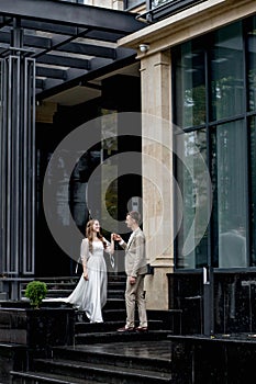 The groom gives his hand to the bride walking down the stairs. Shooting on the wedding day