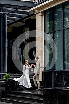 The groom gives his hand to the bride walking down the stairs. Shooting on the wedding day