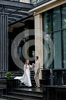 The groom gives his hand to the bride walking down the stairs. Shooting on the wedding day