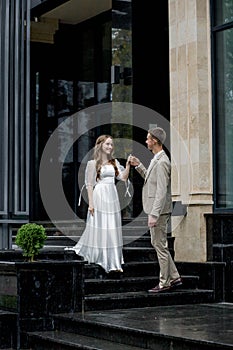 The groom gives his hand to the bride walking down the stairs. Shooting on the wedding day