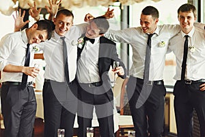 Groom and groomsmen have fun while posing in the restaurant photo