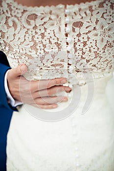 Ženich ruka na nevěsty šaty 