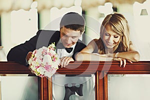 Groom has fun while siitting with a bride at the piano