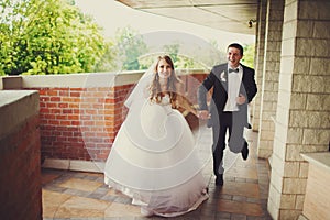 Groom has fun while siitting with a bride at the piano