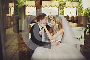 Groom has fun while siitting with a bride at the piano