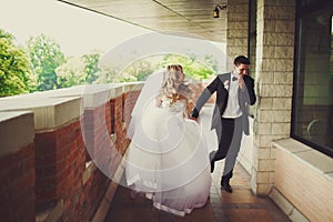 Groom has fun while siitting with a bride at the piano
