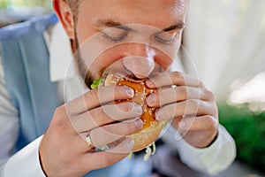 The groom have fun and eat hamburgers. snack for newlyweds.