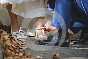 groom helping bride to change shoes