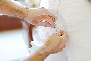 Groom helping bride to put wedding dress on