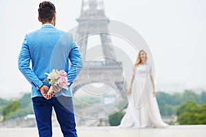 Groom hiding the wedding bouquet behind his back