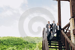 The groom and his friends celebrate the wedding. Men in suits. Mens emotions and friendship.