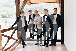 The groom and his friends celebrate the wedding. Men in suits. Mens emotions and friendship.