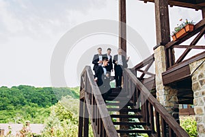 The groom and his friends celebrate the wedding. Men in suits. Mens emotions and friendship.