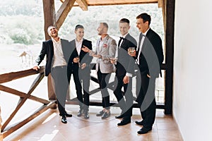 The groom and his friends celebrate the wedding. Men in suits. Mens emotions and friendship.