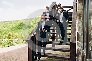 The groom and his friends celebrate the wedding. Men in suits. Mens emotions and friendship.