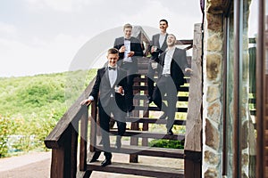 The groom and his friends celebrate the wedding. Men in suits. Mens emotions and friendship.