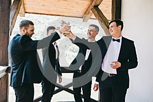 The groom and his friends celebrate the wedding. Men in suits. Murzhsky emotions and friendship.