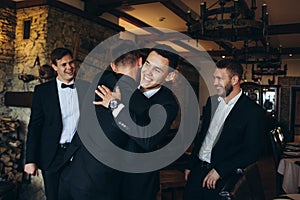 The groom and his friends celebrate the wedding. Men in suits. Murzhsky emotions and friendship.