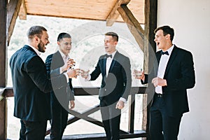 The groom and his friends celebrate the wedding. Men in suits. Murzhsky emotions and friendship.