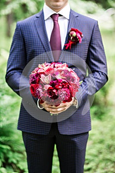 Groom holding flower bouquet