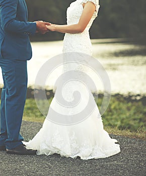 The groom is holding his bride`s hand during the wedding ceremony
