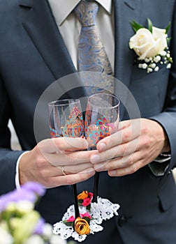 Groom is holding painting champagne glasses