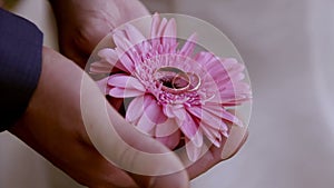 Groom holding the ring in his hand on a flower